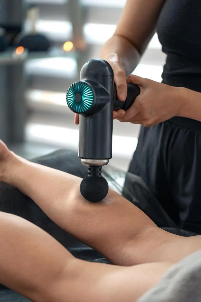 Close-up of a practitioner supporting a client's leg during an assisted stretch